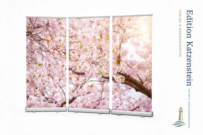 Freigestelltes dreiteiliges Roll-Up Display mit einem durchgehenden, lichtdurchfluteten Kirschblütenmotiv. Das mobile 3er-Set von Edition Katzenstein schafft eine helle, tröstliche Atmosphäre in Trauerhallen, Kapellen und Abschiedsräumen.