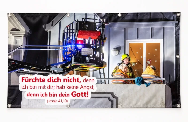 Banner zur Jahreslosung 2027 mit Feuerwehrmann und Ehepaar, Frontlit-Plane im Querformat 200 × 130 cm mit Metallösen.