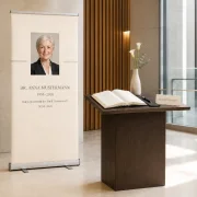 Personalisierte Roll-Up-Gedenkstele neben einem Kondolenzbuch in einem modernen Rathaus - Bestatterbedarf