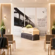 Roll-Up Display 3er-Set „Von guten Mächten“ im Einsatz in einer modernen deutschen Trauerhalle mit Sarg und dezentem Blumenschmuck