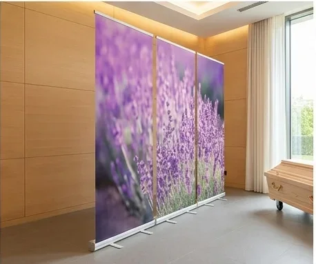 Seitliche Perspektive eines mehrteiligen Lavendel Roll-Up Displays neben einem Sarg in einer hellen Trauerhalle