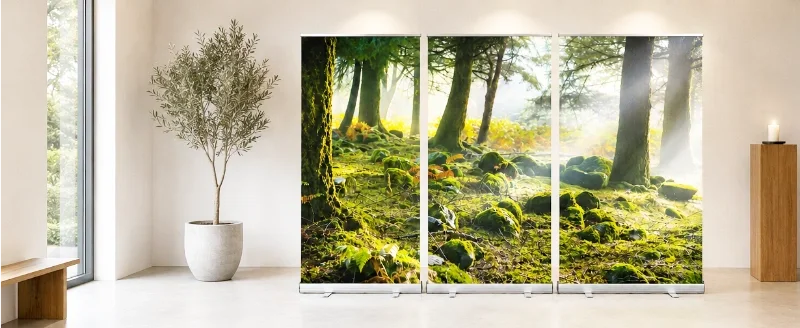 Dreiteiliges Roll-Up Display mit lichtdurchflutetem Mooswald in einem modern gestalteten Showroom mit heller Architektur und natürlichen Materialien.
