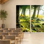 Dreiteiliges Roll-Up Display mit Mooswald-Panorama als Hintergrundgestaltung einer modernen Trauerhalle mit Bestuhlung und Rednerpult. - Infinty