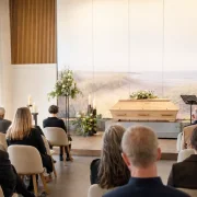 Angehörige und Trauergäste bei einer würdevollen Trauerfeier in einer einfühlsam gestalteten Trauerhalle