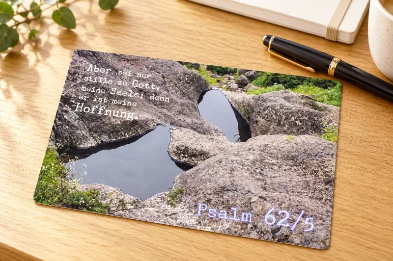 Christliche Postkarte auf hellem Schreibtisch Wasserlachen in Felsen