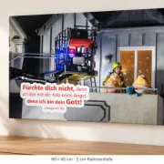 Leinwandbild zur Jahreslosung 2027 mit Feuerwehrmotiv in 60 × 40 cm über einer Holzkonsole, seitlich mit sichtbarer Leinwandkante.