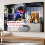 XXL-Leinwandbild zur Jahreslosung 2027 mit Feuerwehrmotiv in 160 × 120 cm und 4 cm Rahmentiefe über einer Holzbank in kirchlichem Ambiente.