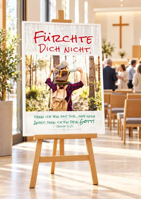 Poster Jahreslosung 2027 auf einer Staffelei im Gemeindesaal DIN-A1-Poster zur Jahreslosung 2027 auf einer Holzstaffelei in einem modernen Gemeindesaal