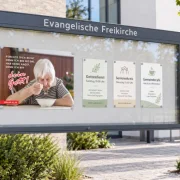 Das DIN-A1-Poster „Du bist nicht allein“ zur Jahreslosung 2027 in einem modernen Gemeindeschaukasten. Ideal zur Verbindung von biblischem Zuspruch und Einladungen zu Gottesdienst, Seniorenkreis und Gemeindecafé.