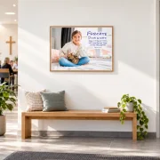 Gerahmtes Poster zur Jahreslosung 2027 mit Mädchen und Katze im DIN-A1-Querformat über einer Bank im Gemeindefoyer einer FEG