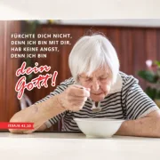 Poster Jahreslosung 2027 DIN A2 Du bist nicht allein – Betagte Seniorin am Tisch mit Bibelvers Jesaja 41,10