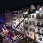 Ein Feuerwehreinsatz bei Nacht in einer Strasse mit Altbauhäusern