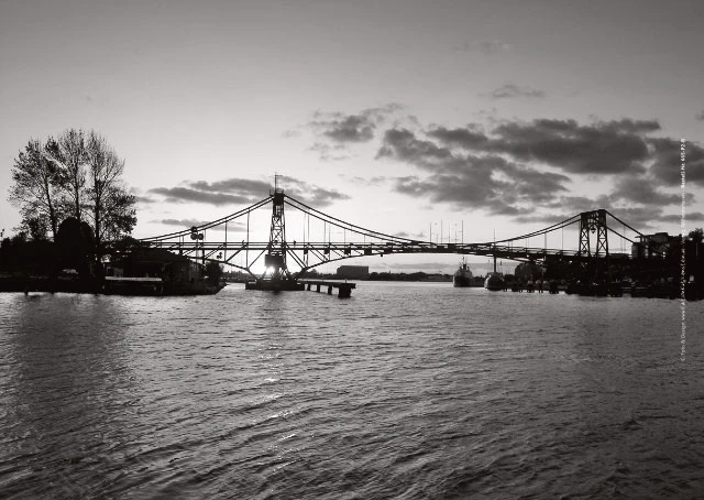 Monumentale Stahlbrücke im hellen Gegenlicht.